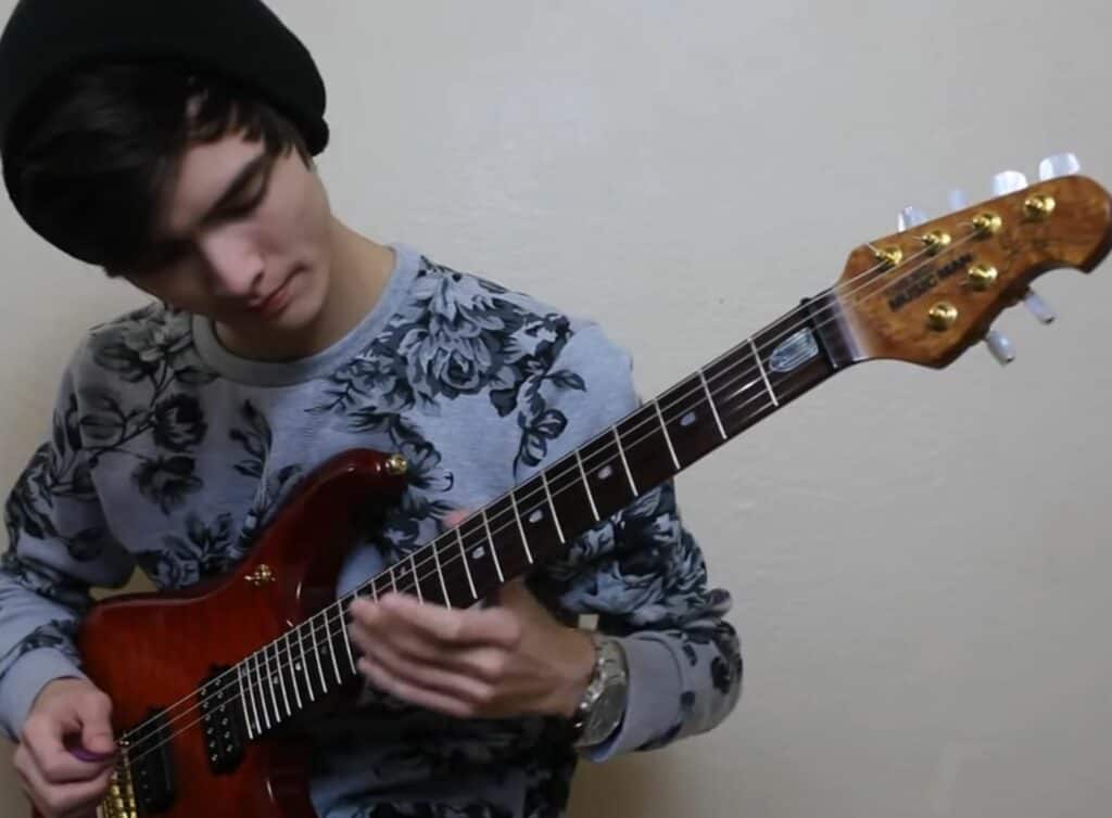 Tim Henson playing a Music Man John Petrucci guitar. 